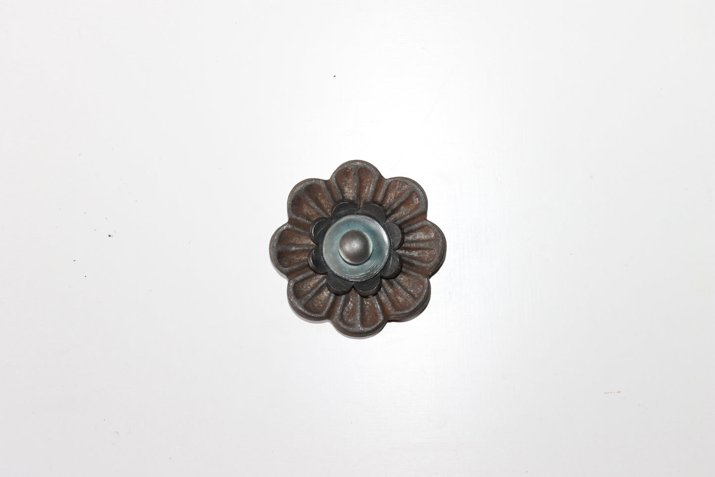 Handgemaakte stalen bloemen op een robuuste poutrel, compleet met decoratieve rivet-details