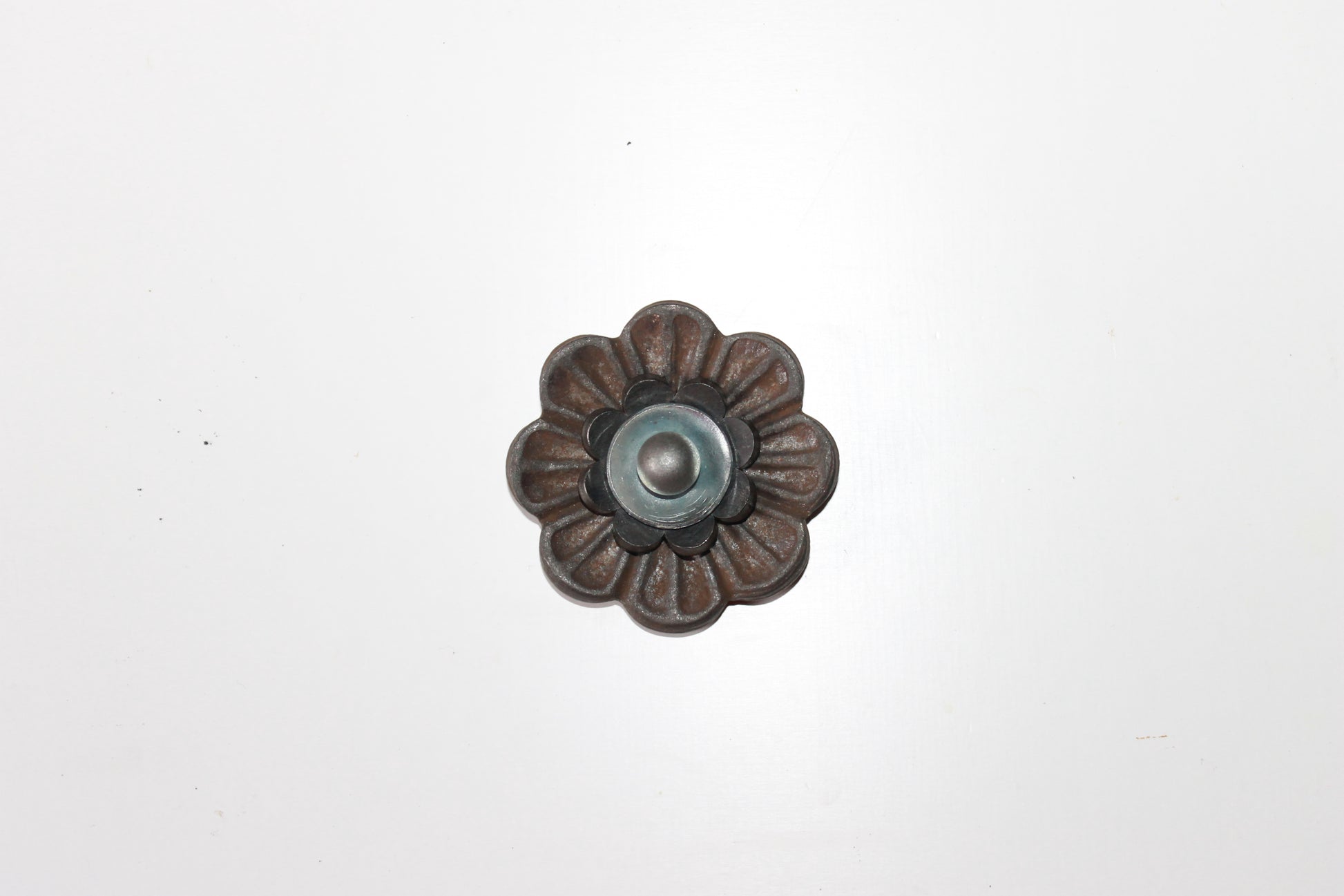 Handgemaakte stalen bloemen op een robuuste poutrel, compleet met decoratieve rivet-details